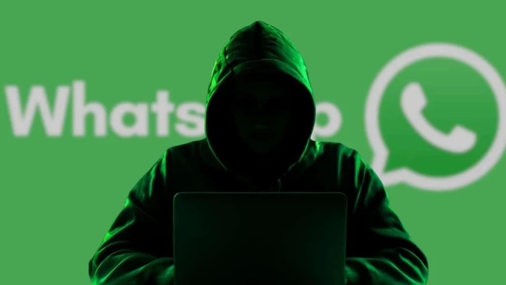 Hacker encapuzado usando notebook com fundo verde do WhatsApp, ilustrando golpes que visam carteiras de criptomoedas